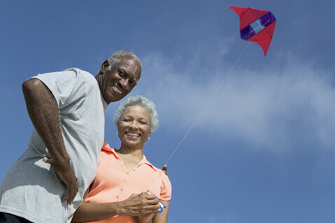 Mature African American couple flying a kite