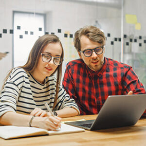 Couple wearing eyeglasses at laptop