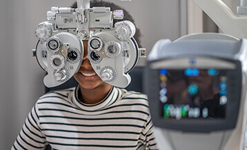 Woman having eyes examined with phoropter