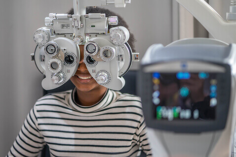 Woman having eyes examined with phoropter