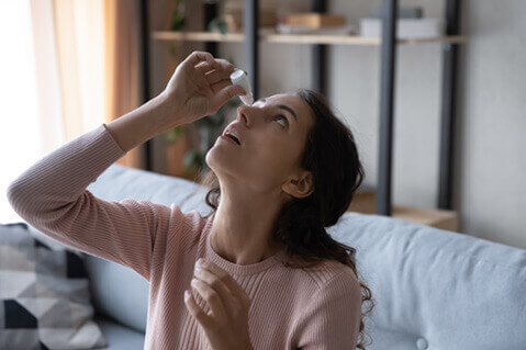 Woman putting in eye drops to help with dry eyes